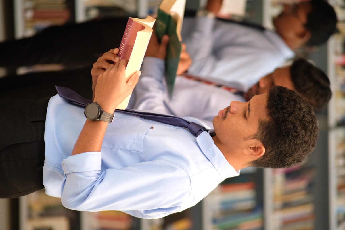 A student reading among the book stacks at Starr Library, Andhra Bible College